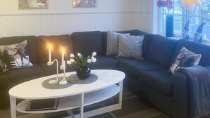 A modern living room with a dark blue sofa, white coffee table, and decorative pillows. - 10 Person Holiday Home in Syssleback-by Traum (Sysslebäck)