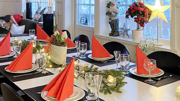 A dining table set for a meal with red napkins, clear glasses, and a decorative centerpiece. - 10 Person Holiday Home in Syssleback-by Traum (Sysslebäck)