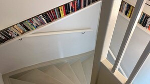 A spiral staircase with a bookshelf at the top. - 5 Star Holiday Home in Limhamn (Malmö)