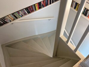 A spiral staircase with a bookshelf at the top. - 5 Star Holiday Home in Limhamn (Malmö)