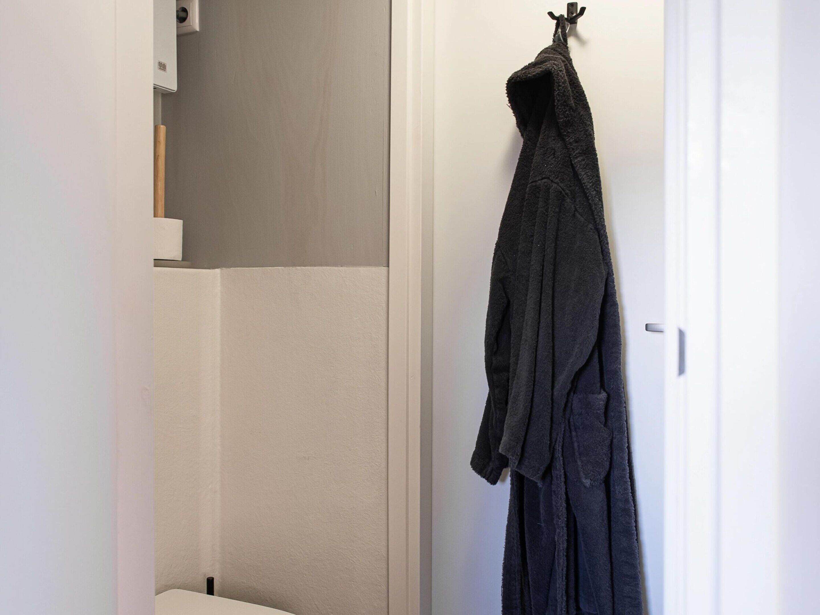 A bathroom with a towel rack holding a dark towel.