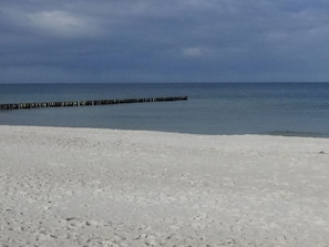 A beach with a wooden jetty extending into the water. - Seeschwalbe Modern Retreat (Fuhlendorf)