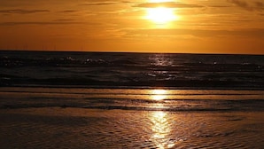 Un atardecer sobre el océano con olas que reflejan la luz del sol.