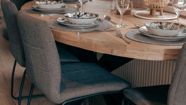 Una mesa puesta con platos, cuencos, cubiertos y vasos.