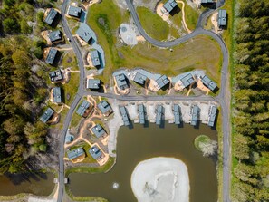 Vista aérea de una zona residencial con varias casas, un camino sinuoso y una gran masa de agua.