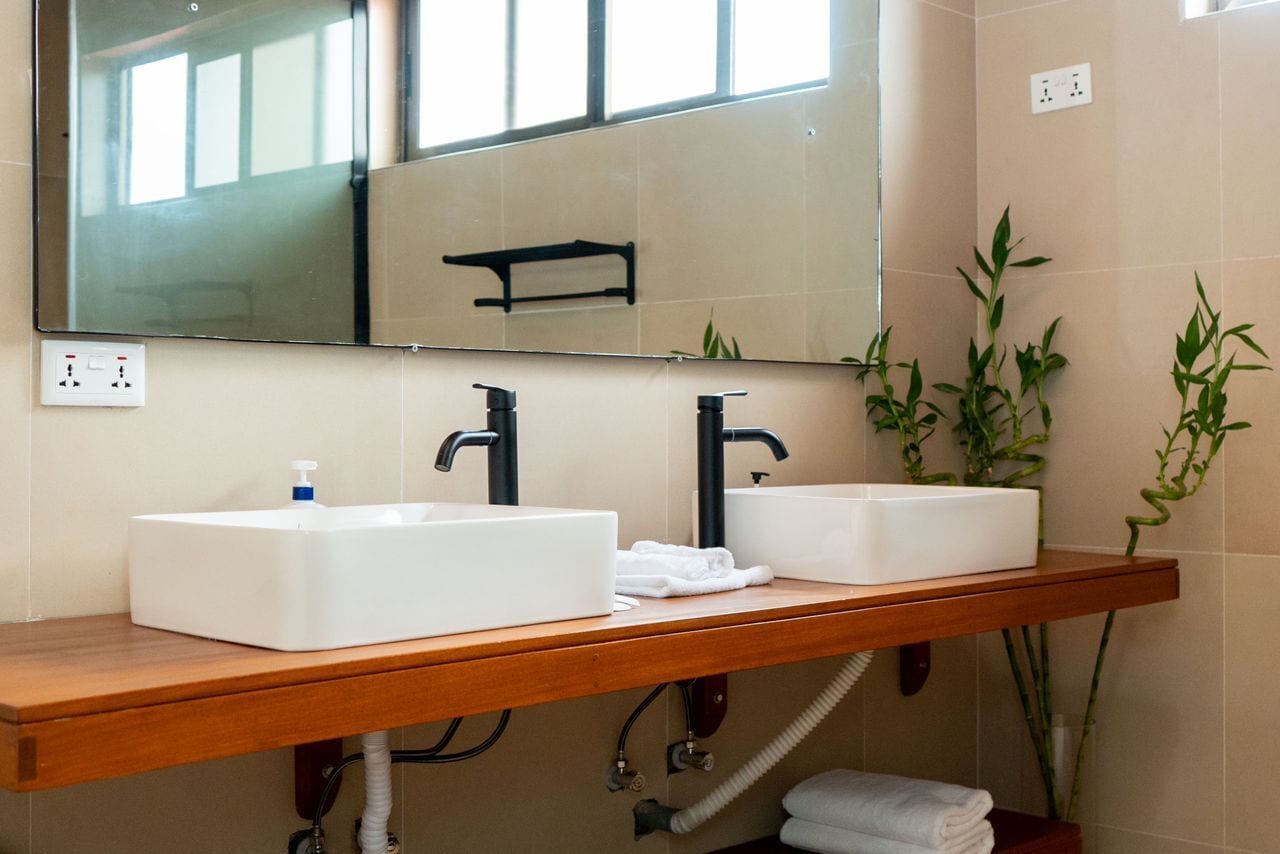Une salle de bain avec deux lavabos, un miroir et un comptoir en bois.