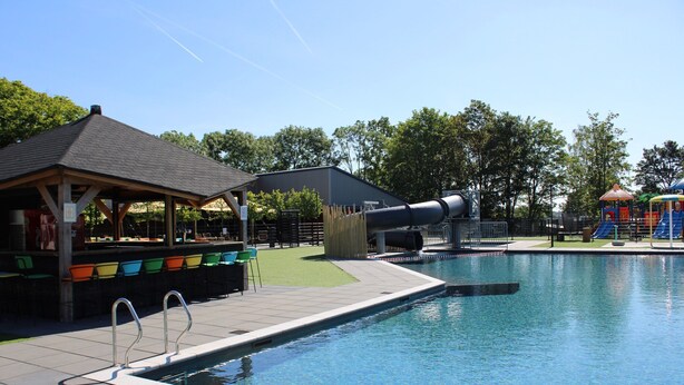 A swimming pool with a covered seating area and a slide. - Chalet With Dishwasher in a Park (Lathum)