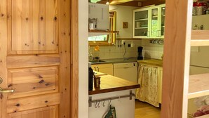 A wooden door leading into a kitchen with white cabinets, a sink, and a countertop. - 4 Star Holiday Home in Annerstad (Annerstad)