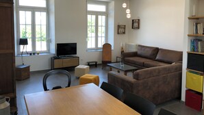 En moderne stue med sofa, fjernsyn og spiseplads.