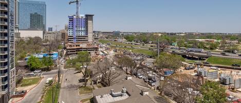 A construction site with a crane, a parking lot, and a highway in the background.