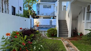 Un sendero estrecho que lleva a un edificio blanco con una escalera.