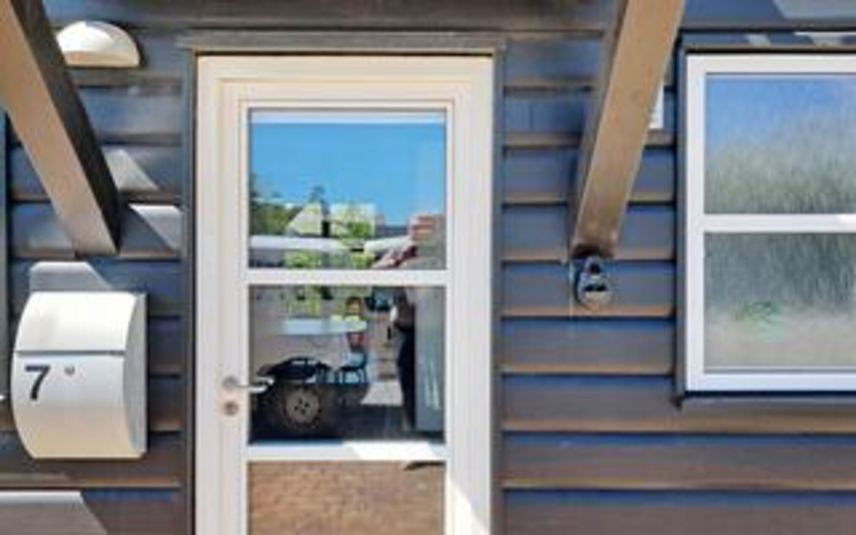 A residential building with a door, a mailbox, and a window.