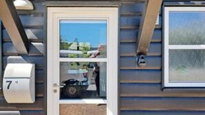 A residential building with a door, a mailbox, and a window. - 4 Person Holiday Home in Blavand (Blavand)