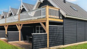 A building with a balcony and a covered outdoor seating area. - 4 Person Holiday Home in Blavand (Blavand)