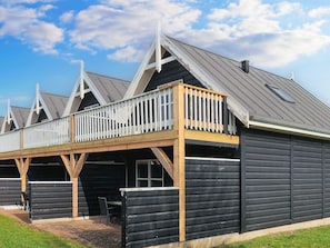 Un bâtiment doté d’un balcon et d’un espace extérieur aménagé et abrité.