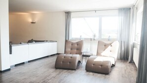A modern living room with a sofa set, ottomans, and a dining table. - Holiday Apartment Festungsberg (Koblenz)