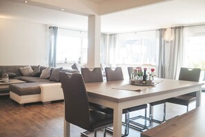 A modern living room with a sofa, dining table, and chairs. - Holiday Apartment Festungsberg (Koblenz)