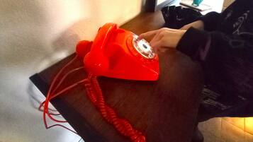 Un téléphone à cadran rouge posé sur une table en bois.