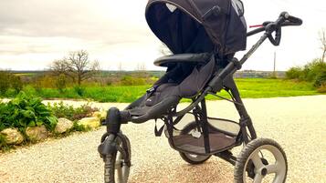 Ein Kinderwagen mit Verdeck, großen Rädern und einem Lenker.
