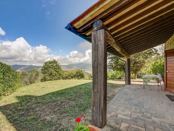 Step into a serene outdoor oasis with a brick pathway leading to a seating area and lush green views.