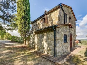 Standalone residence surrounded by a serene garden with a tall evergreen tree.