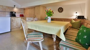 A dining area with a table, chairs, and a sofa. - Haus Brandl Modern Retreat (Ramsau bei Berchtesgaden)