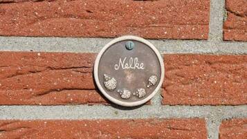 Un muro de ladrillo con una placa metálica que dice "Nelke".