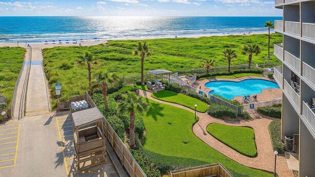 A resort with a pool, a beach view, and a parking area. - Aquarius 408 2 Bedroom Condo by RedAwning (South Padre Island)