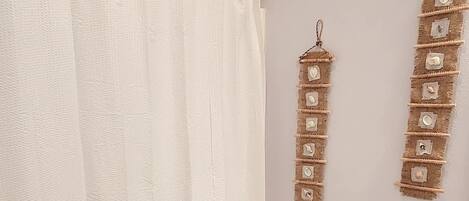 A bathroom with a white toilet, a shower curtain, and a sink with a beige countertop.