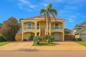 A two-story residential building with a central entrance, a covered front porch, and a two-car garage. - Beach & Palms Condo 2 Bedroom Condo by RedAwning (South Padre Island)