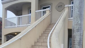A building with a curved staircase leading to a balcony. - Beach & Palms Condo 2 Bedroom Condo by RedAwning (South Padre Island)