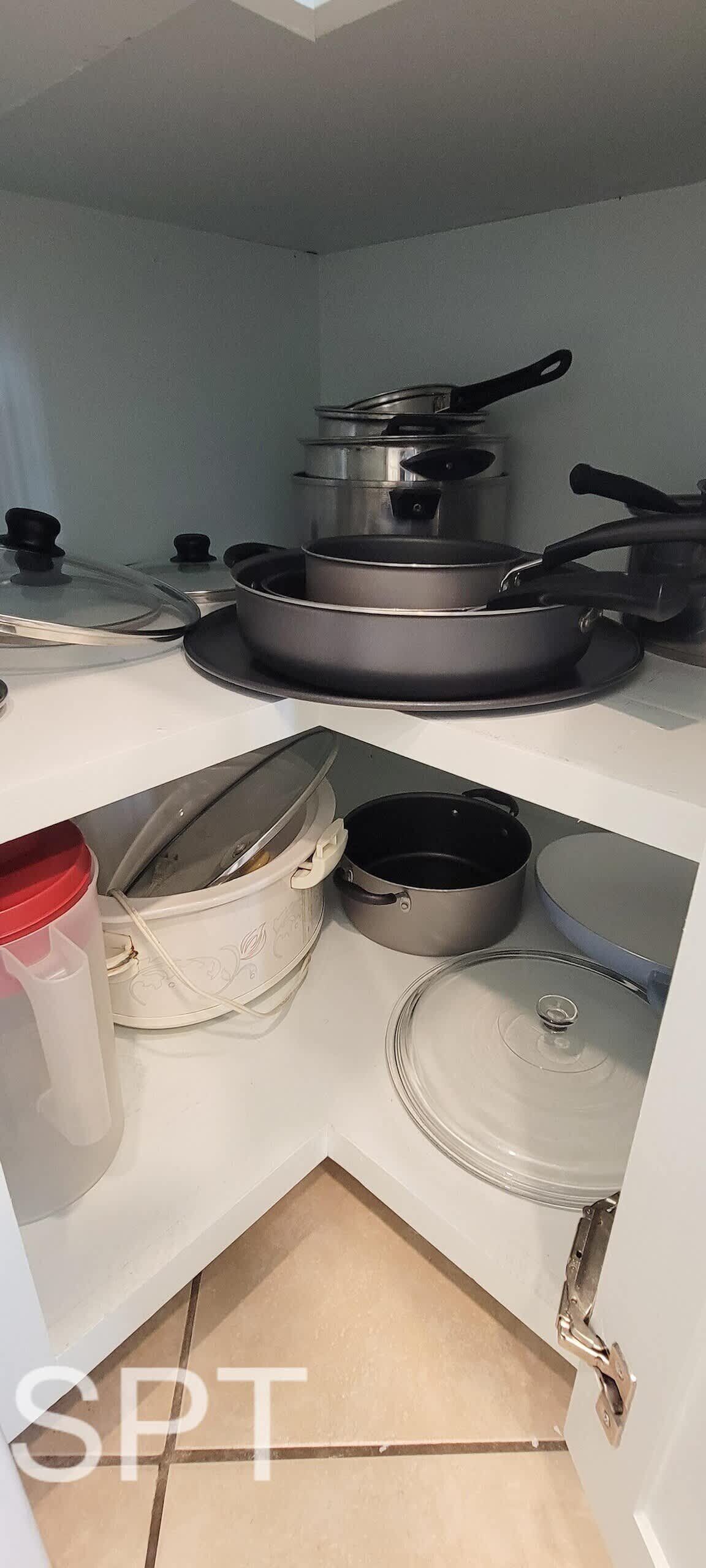 A kitchen with a stove, pots, pans, and a coffee maker.