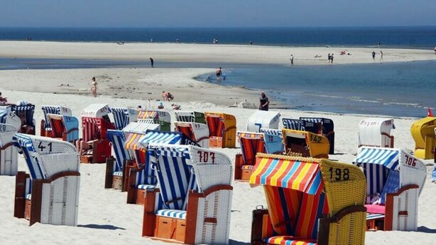 Beach chairs with numbers, arranged on a sandy beach. - 3 in Haus Pax Modern Retreat (Nebel)