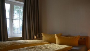 A bedroom with two beds, a window with curtains, and a bedside lamp. - 3 in Haus Pax Modern Retreat (Nebel)