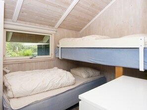 A bunk bed room with a window, a desk, and a bed with pillows. - 6 Person Holiday Home in Farvang (Farvang)