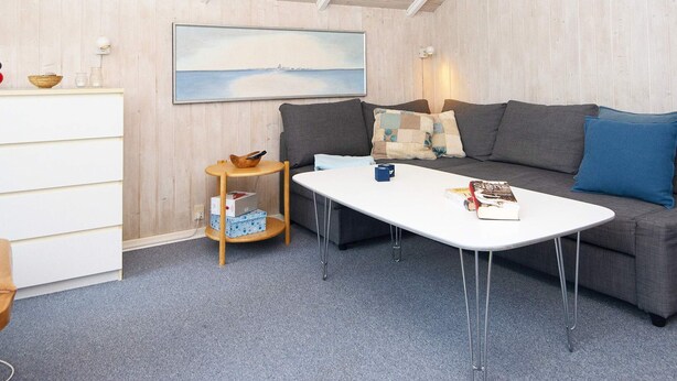 Ein gemütliches Wohnzimmer mit einer Couch, einem Couchtisch und einem kleinen Beistelltisch.