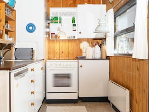 A compact kitchen with wooden cabinets, a built-in oven, and a refrigerator. - 6 Person Holiday Home in Grenaa (Grenaa)