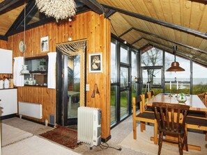 A wooden interior with a dining area, kitchen, and large windows. - 6 Person Holiday Home in Grenaa (Grenaa)