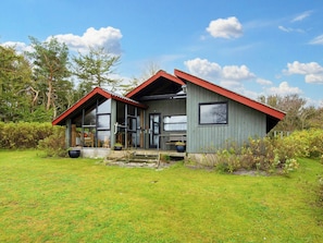 A two-story house with a red roof, large windows, and a grassy yard. - 6 Person Holiday Home in Grenaa (Grenaa)