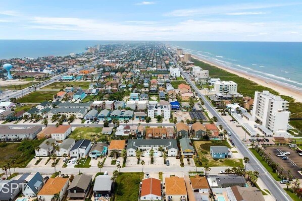 Un área residencial costera con playa, casas y una carretera que conduce a la playa.