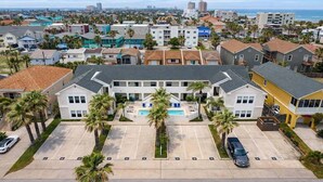 A multi-story building with a central courtyard, parking spaces, and a view of the surrounding neighborhood.