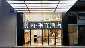 A hotel entrance with a modern design, featuring a glass facade and a sign in both English and Chinese. - JIAN.SHIGUAN HOTEL (Dongguan)