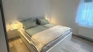 Une chambre à coucher moderne avec un lit, des tables de chevet et une fenêtre.
