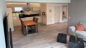 Un appartement moderne comprenant un coin repas, une cuisine et un espace de vie.
