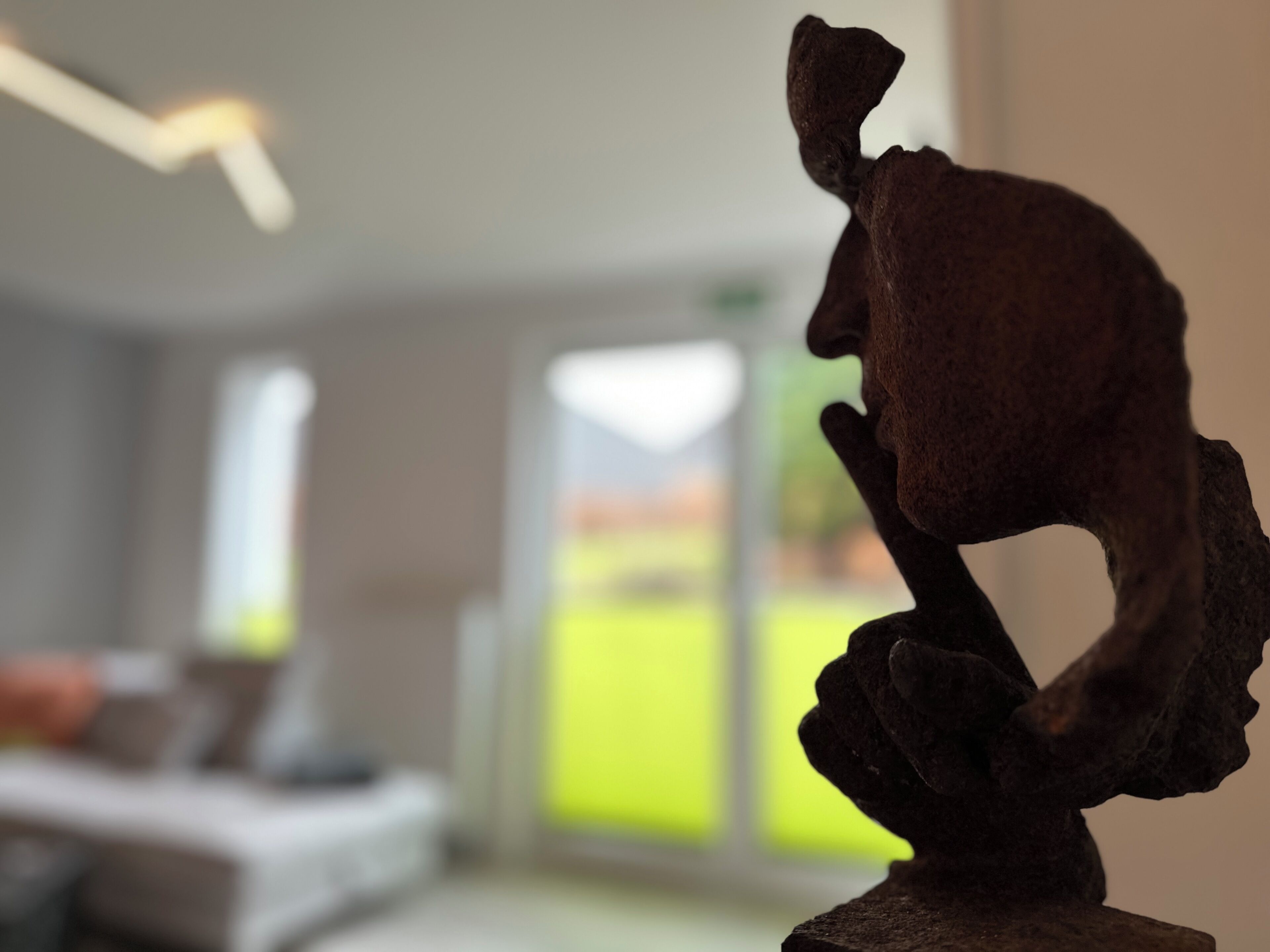 A sculpture in a room with a bed and a window.