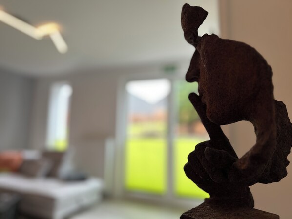 A sculpture in a room with a bed and a window.