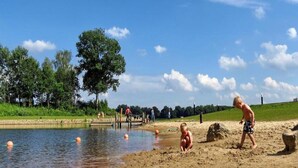 A sandy beach with a pond, trees, and a clear sky. - Chalet With Covered Terrace in the Leukermeer (Well)