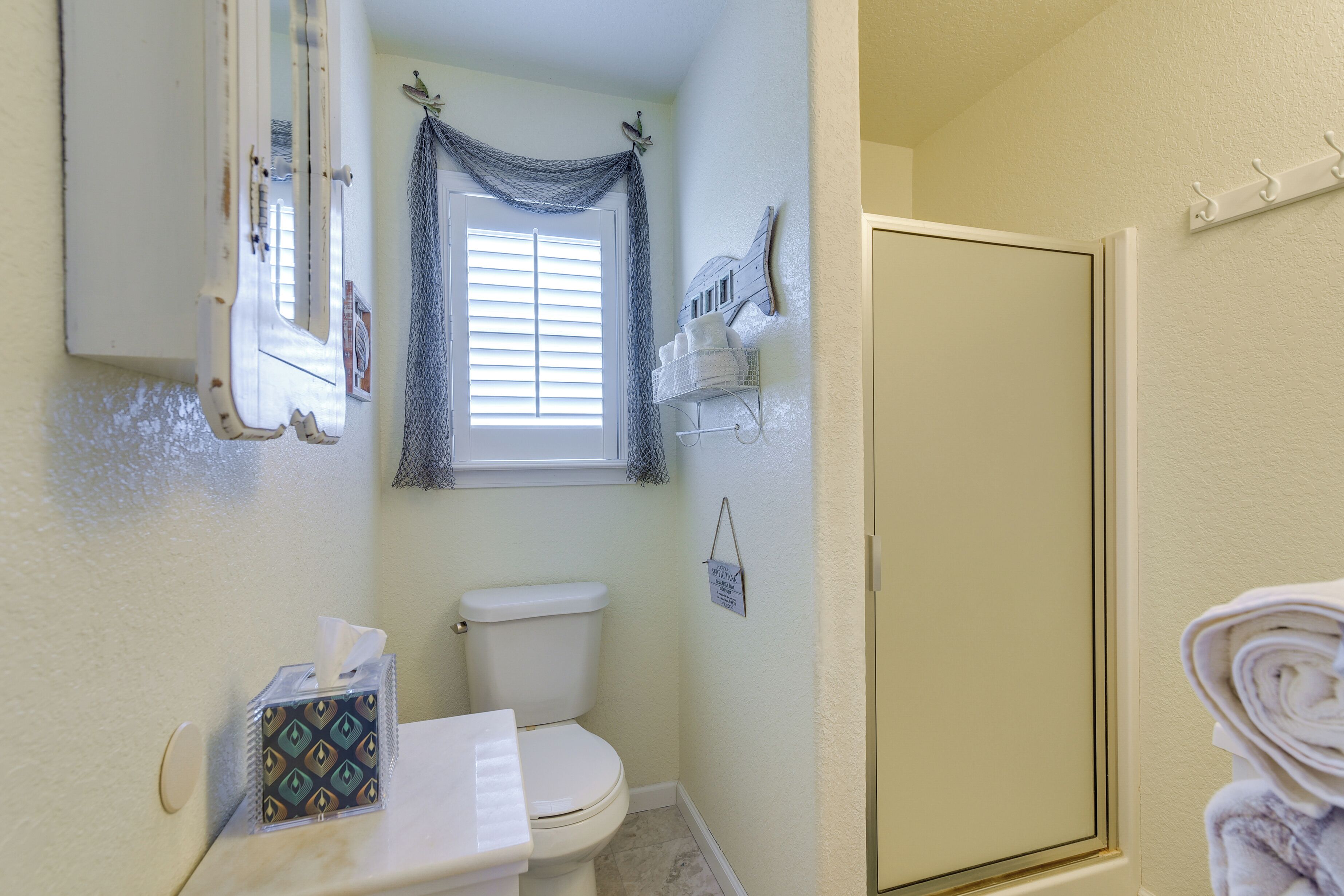 Une salle de bain équipée de toilettes, d’un porte-serviettes et d’une porte de douche.