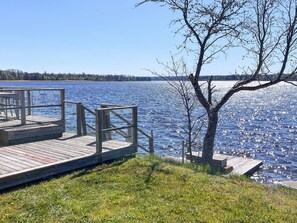 Une jetée en bois s’étendant sur un lac paisible, sous un ciel dégagé.