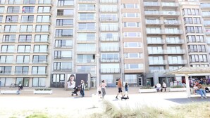 A multi-story residential building with balconies, a central courtyard, and a small kiosk. - Apartment in Nieuwpoort With sea View (Nieuwpoort)